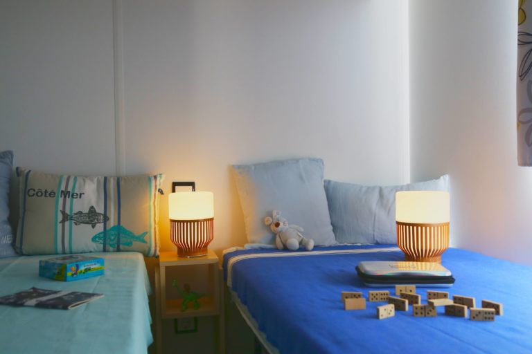 Chambre avec lits, lampes et jouets décoratifs.