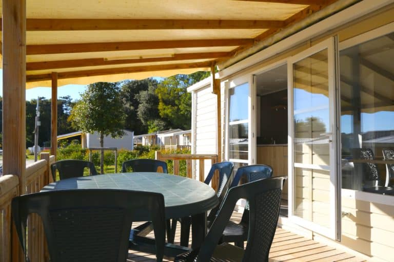 Terrasse ensoleillée avec table et chaises noires