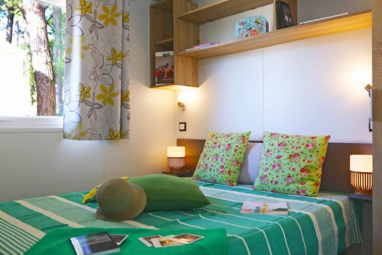 Chambre lumineuse avec décoration verte et florale.