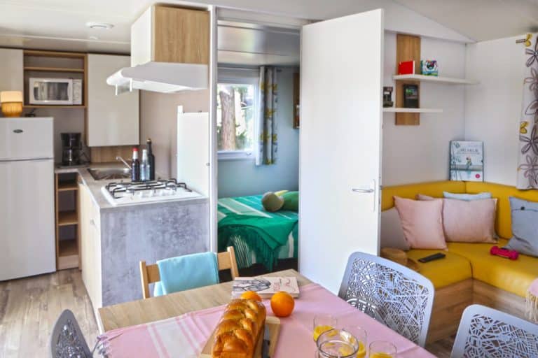 Intérieur de mobil-home lumineux avec cuisine équipée.