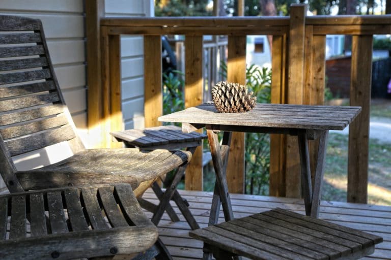 Terrasse bois avec meuble rustique et pomme de pin.